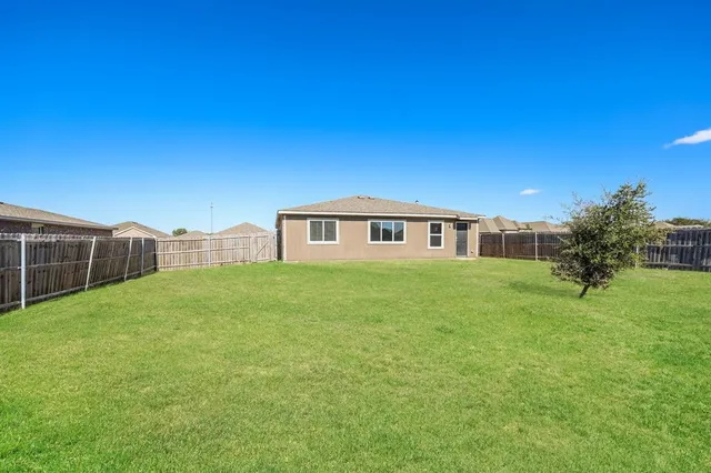a backyard of a house with lots of green space and plants
