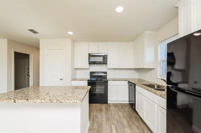 a kitchen with stainless steel appliances granite countertop a stove and a sink