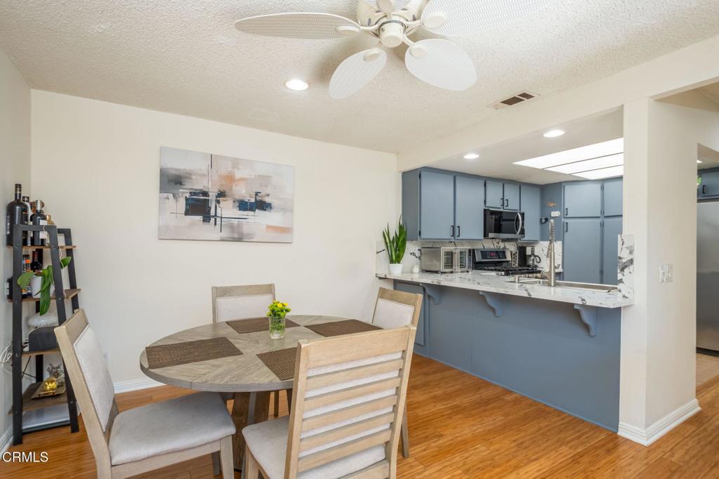 3610 Isle Way Oxnard, CA 93035 - Photo 11 of 25 a kitchen with kitchen island a dining table chairs stainless steel appliances and cabinets