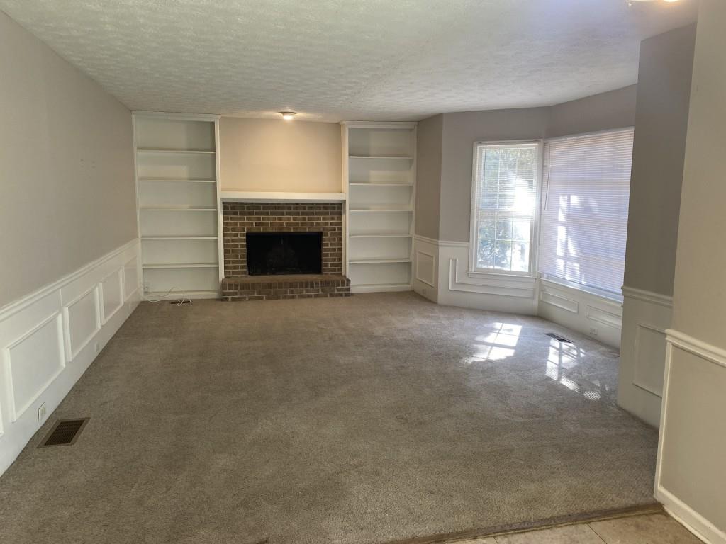 1720 Ridgefield Drive Roswell, GA 30075 - Photo 2 of 35 an empty room with a fireplace and window