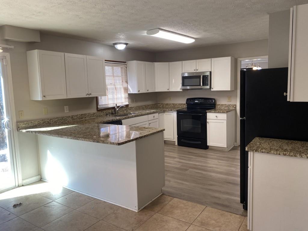 1720 Ridgefield Drive Roswell, GA 30075 - Photo 7 of 35 a kitchen with stainless steel appliances granite countertop a stove top oven a refrigerator a sink and dishwasher
