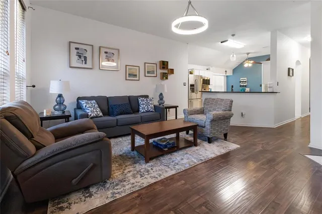 a living room with furniture a wooden floor and a chandelier