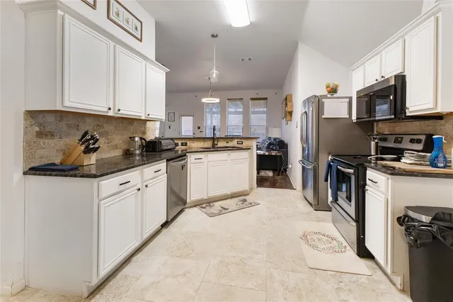 a kitchen with stainless steel appliances granite countertop a refrigerator sink and cabinets