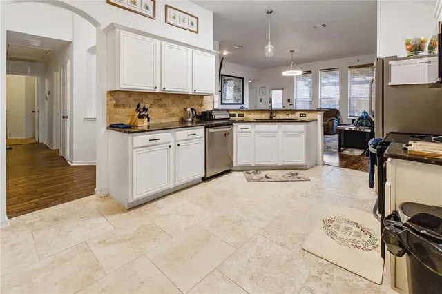 a kitchen with stainless steel appliances granite countertop a stove top oven a sink a counter space and cabinets