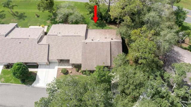 an aerial view of residential house with outdoor space and trees all around