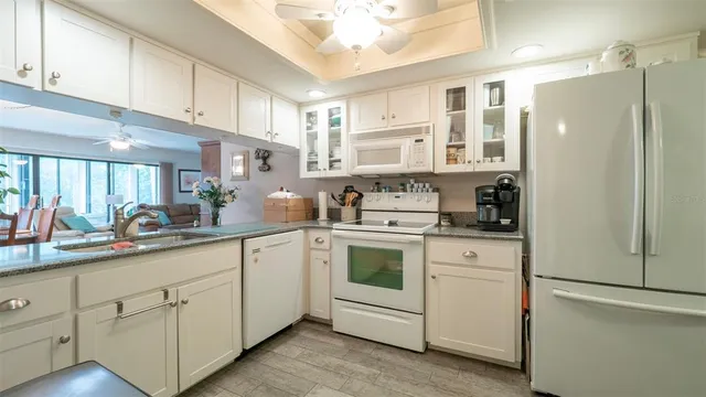 a kitchen with white cabinets and white appliances
