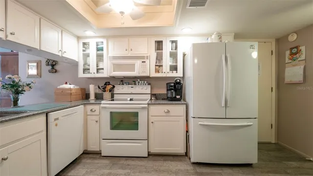 a kitchen with white cabinets and white appliances