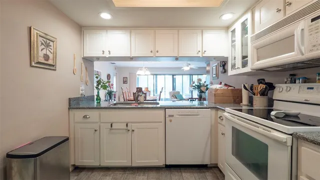 a kitchen with white cabinets and white appliances