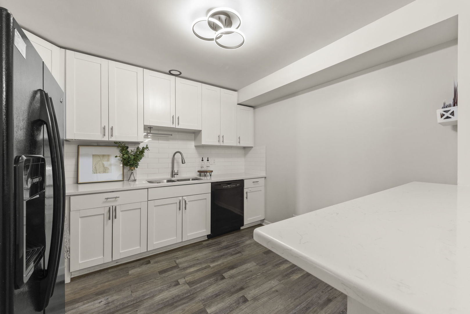 1002 Spruce Street, Unit 2B Glendale Heights, IL 60139 - Photo 7 of 16 a kitchen with a sink a refrigerator and white cabinets