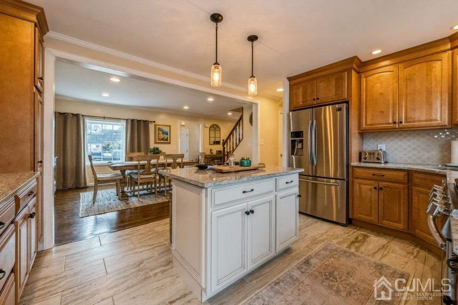 35 Pine Tree Drive Colonia, NJ 07067 - Photo 15 of 39 a kitchen with stainless steel appliances kitchen island granite countertop a refrigerator a stove a sink dishwasher and a dining table with wooden floor