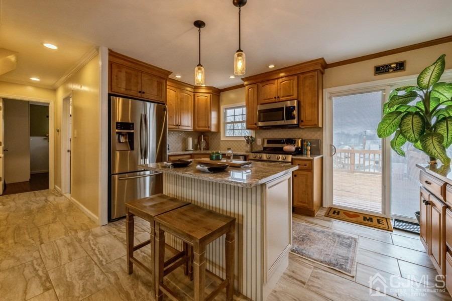 35 Pine Tree Drive Colonia, NJ 07067 - Photo 16 of 39 a kitchen with stainless steel appliances granite countertop a stove a refrigerator a sink a microwave oven with a dining table and chairs
