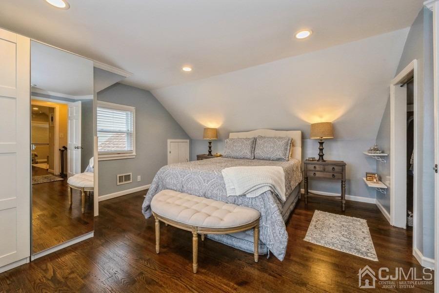 35 Pine Tree Drive Colonia, NJ 07067 - Photo 19 of 39 a bedroom with a bed a table and wooden floor