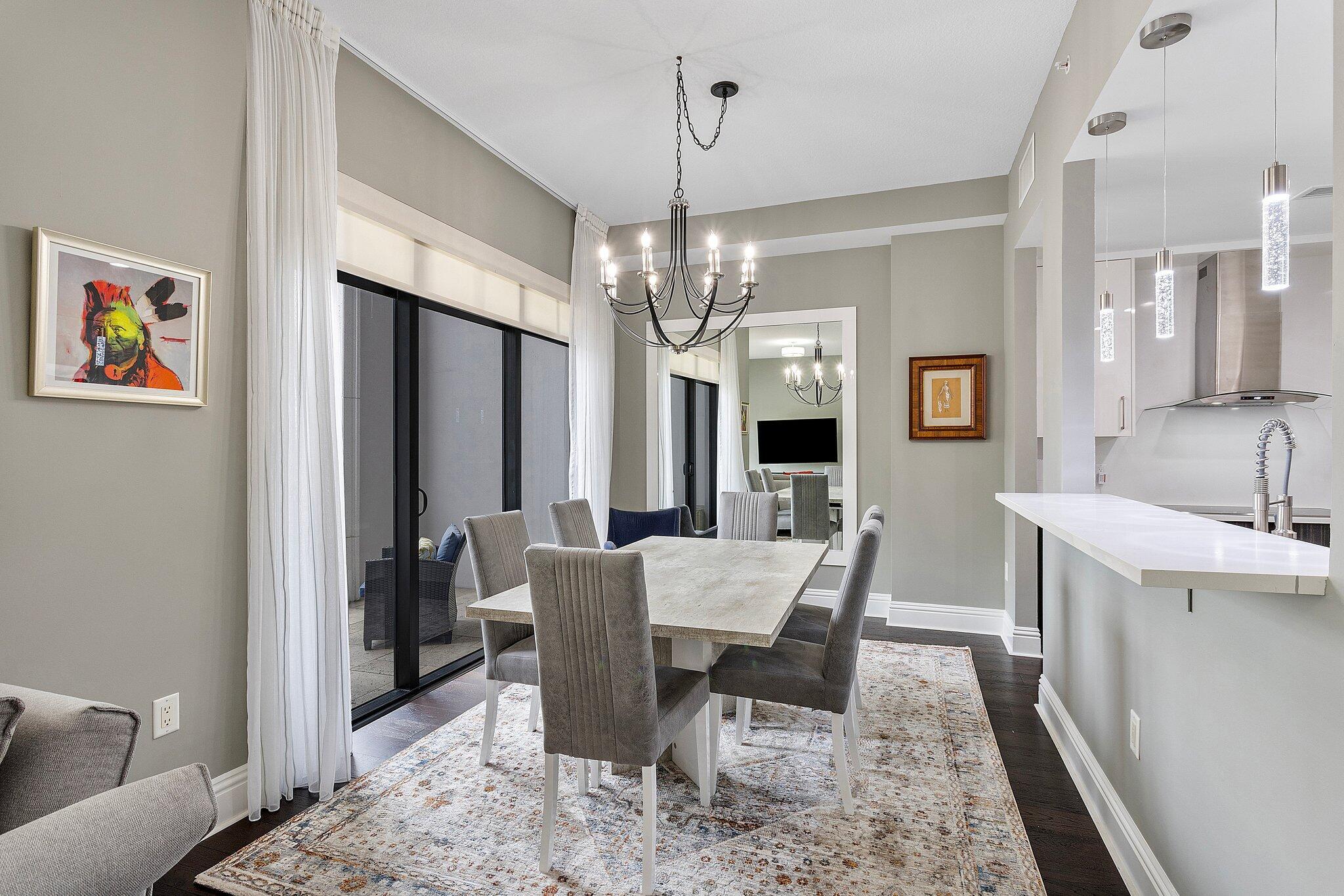 200 East Palmetto Park Road, Unit 10 Boca Raton, FL 33432 - Photo 4 of 47 a view of a dining room with furniture a chandelier and wooden floor