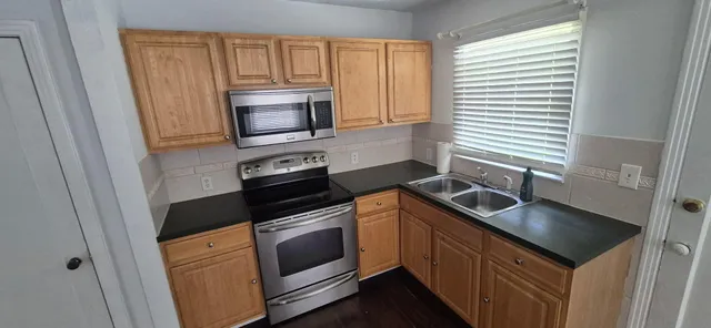 a kitchen with granite countertop a sink and steel stainless steel appliances
