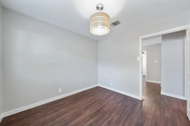a view of a room with wooden floor and white walls