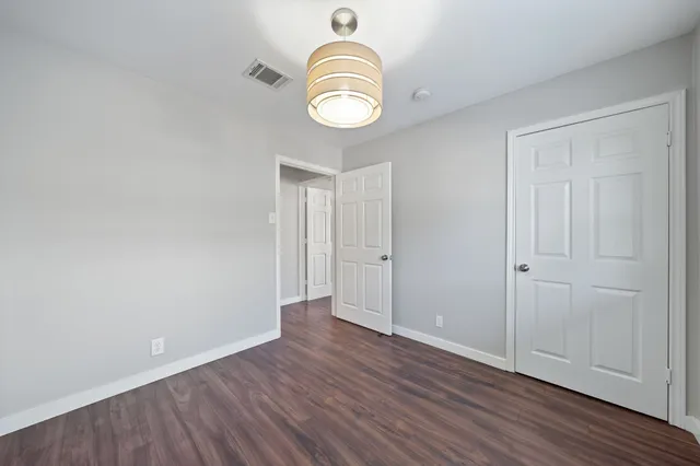 an empty room with wooden floor and window