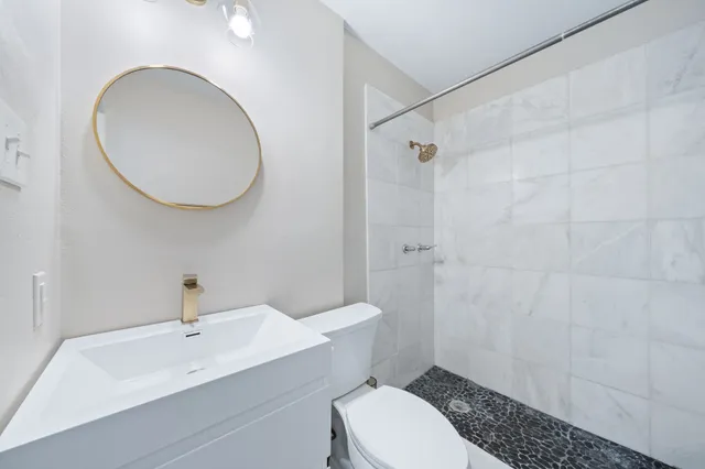 a bathroom with a sink a toilet and a mirror