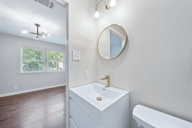 a bathroom with a toilet a sink and mirror