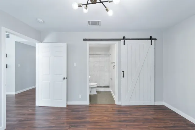 a view of a room with wooden floor and a ceiling fan