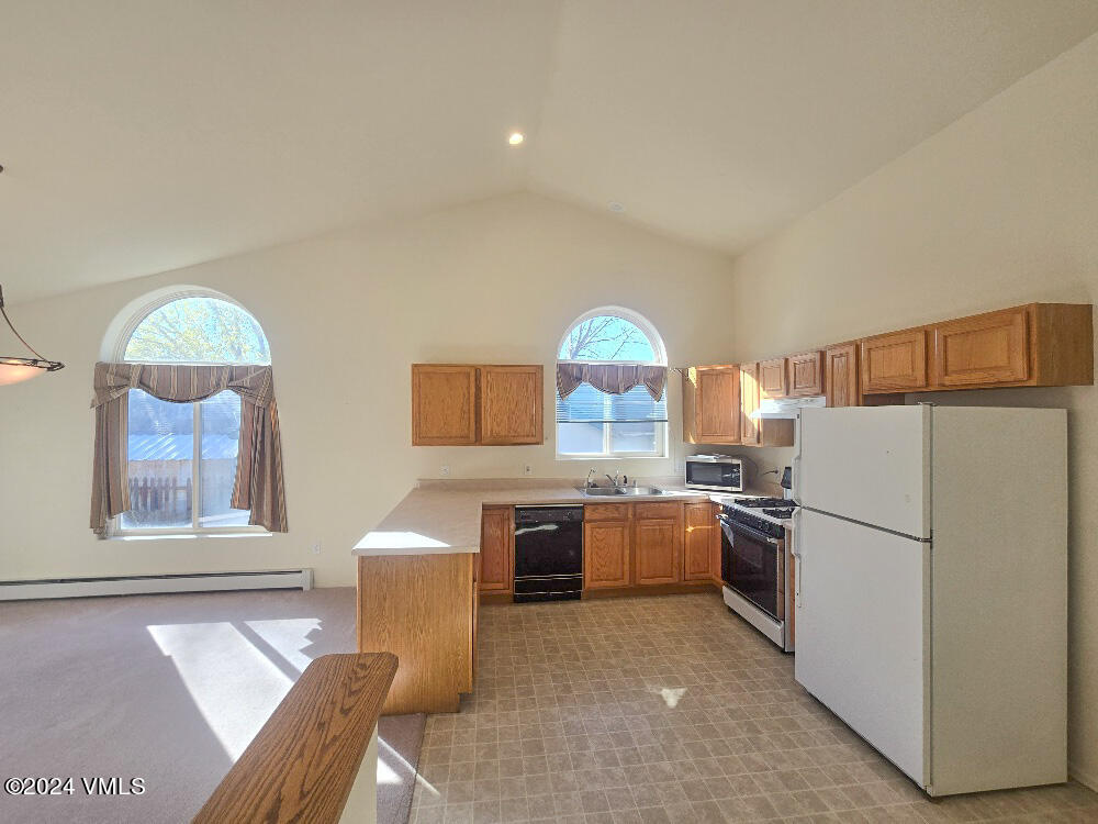 702 Bull Run Eagle, CO 81631 - Photo 12 of 26 a kitchen with stainless steel appliances granite countertop a refrigerator sink stove dining table and chairs