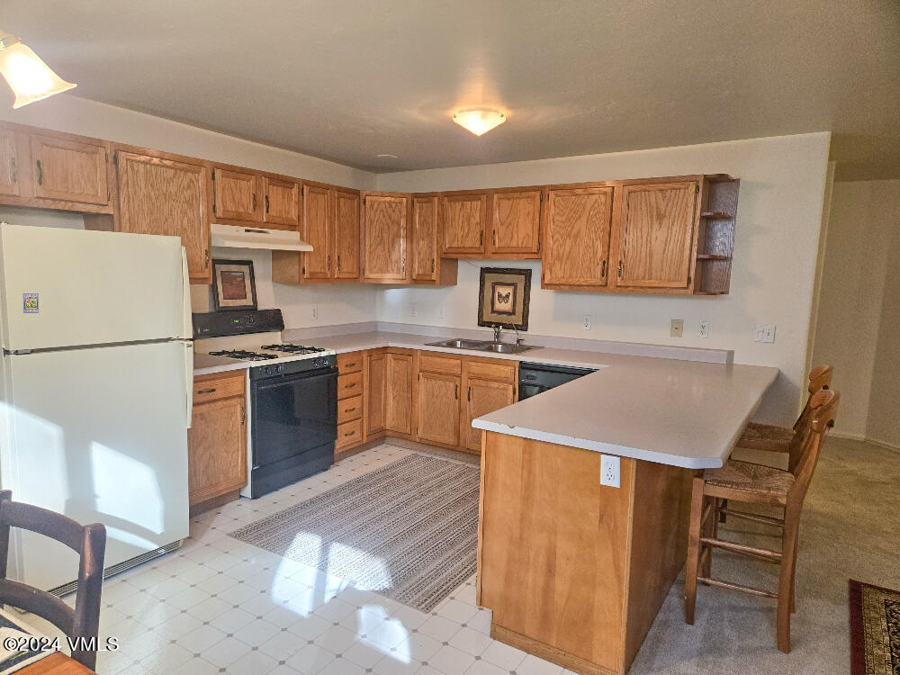702 Bull Run Eagle, CO 81631 - Photo 21 of 26 a kitchen with a refrigerator a stove top oven a sink and cabinets