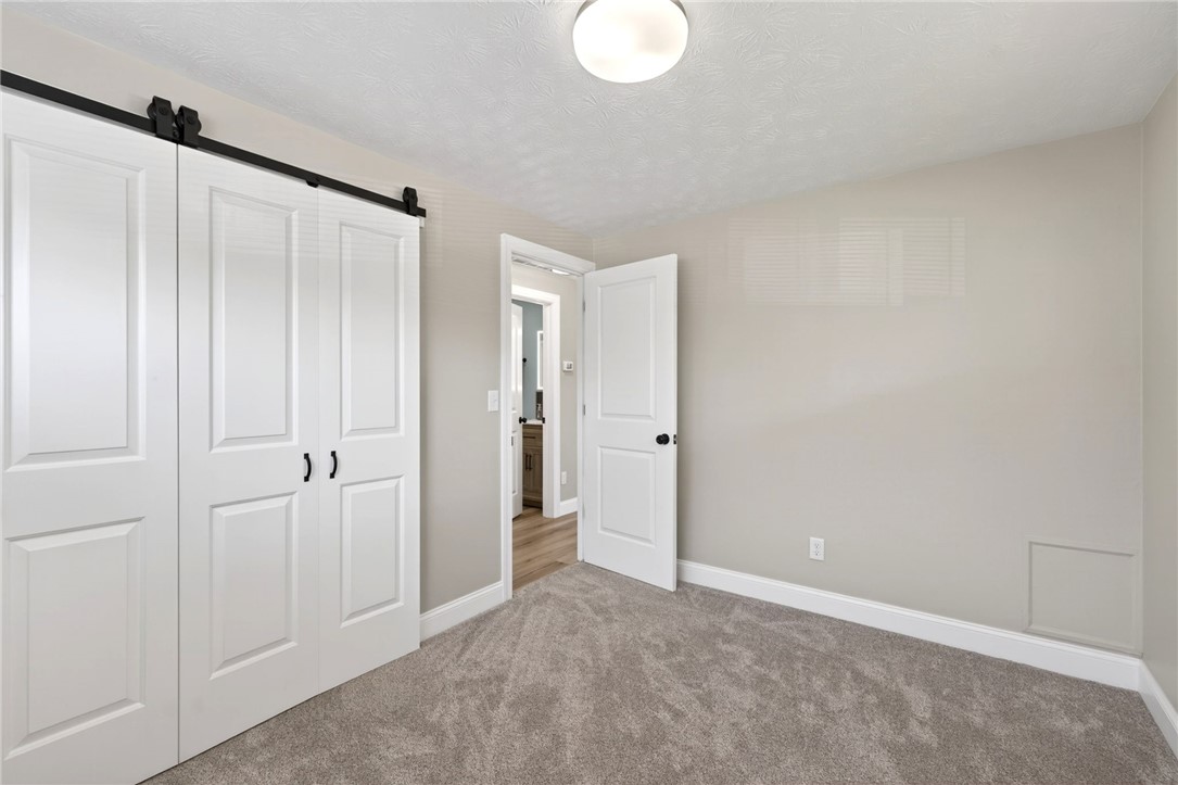 5975 Rosalie Road Dayton, OH 45424 - Photo 20 of 48 This inviting bedroom features soft carpeting and convenient barn doors, offering comfort and style.
