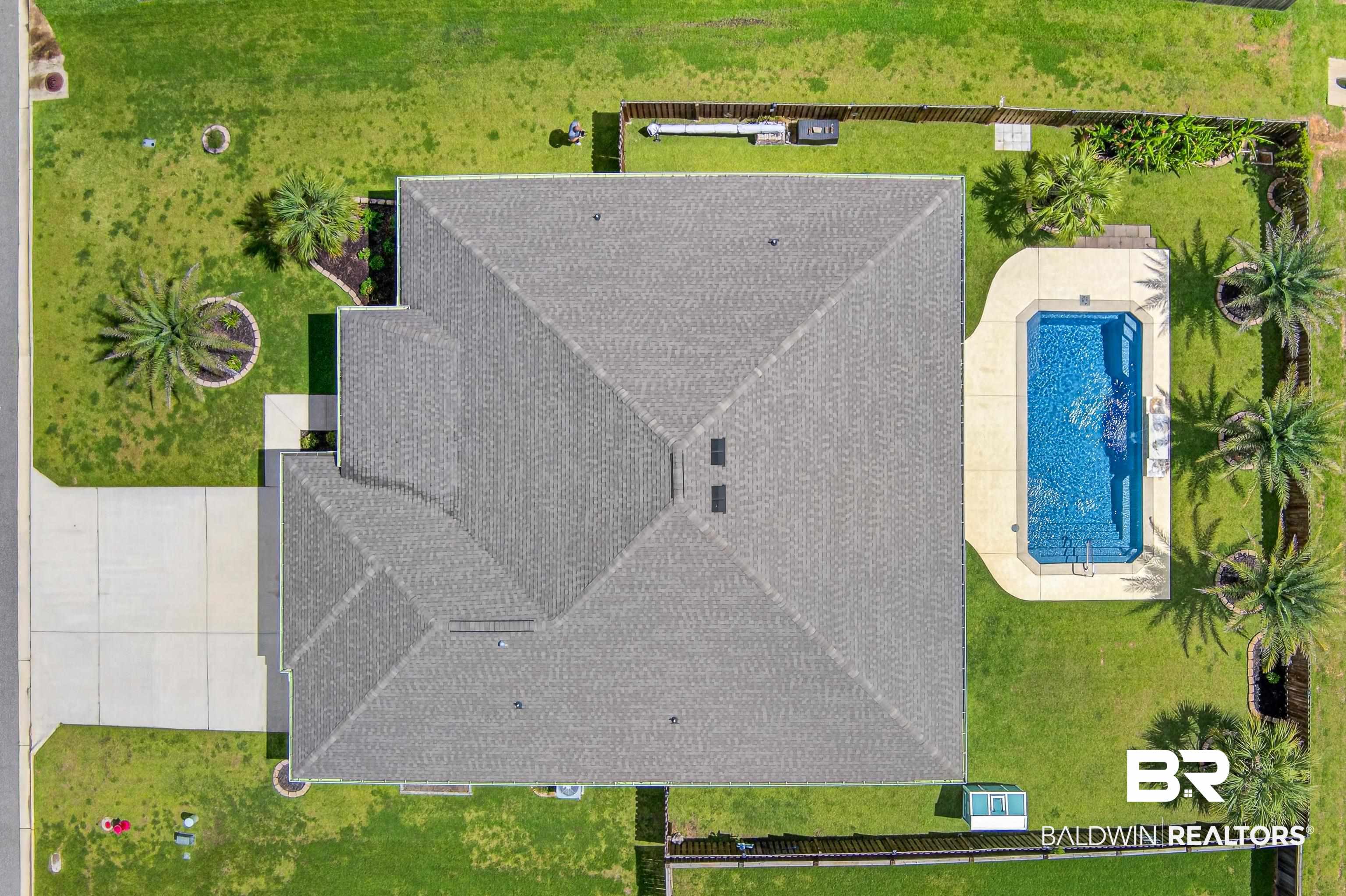 1724 Partridge Street Foley, AL 36535 - Photo 3 of 62 Aerial view showcasing the property's rectangular swimming pool with surrounding deck, extensive green lawn, and mature palm trees