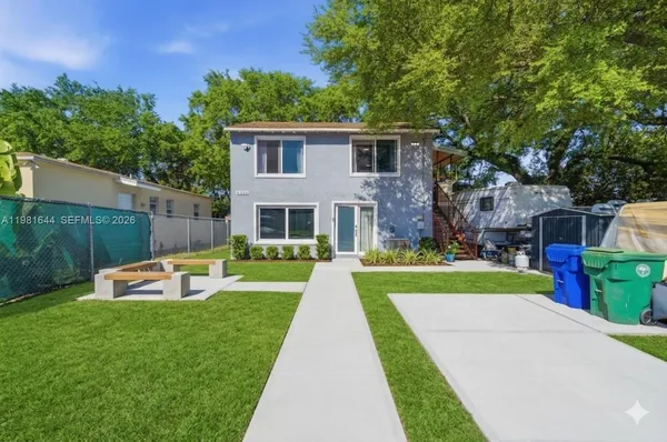 a view of a house with a yard and sitting area