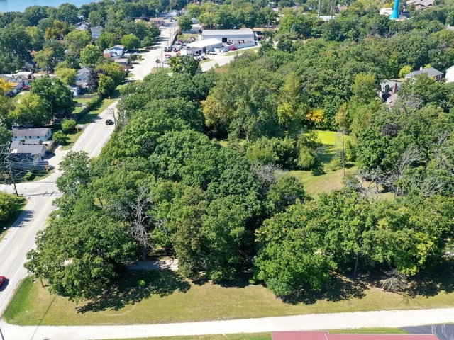 an aerial view of residential house with outdoor space and trees all around