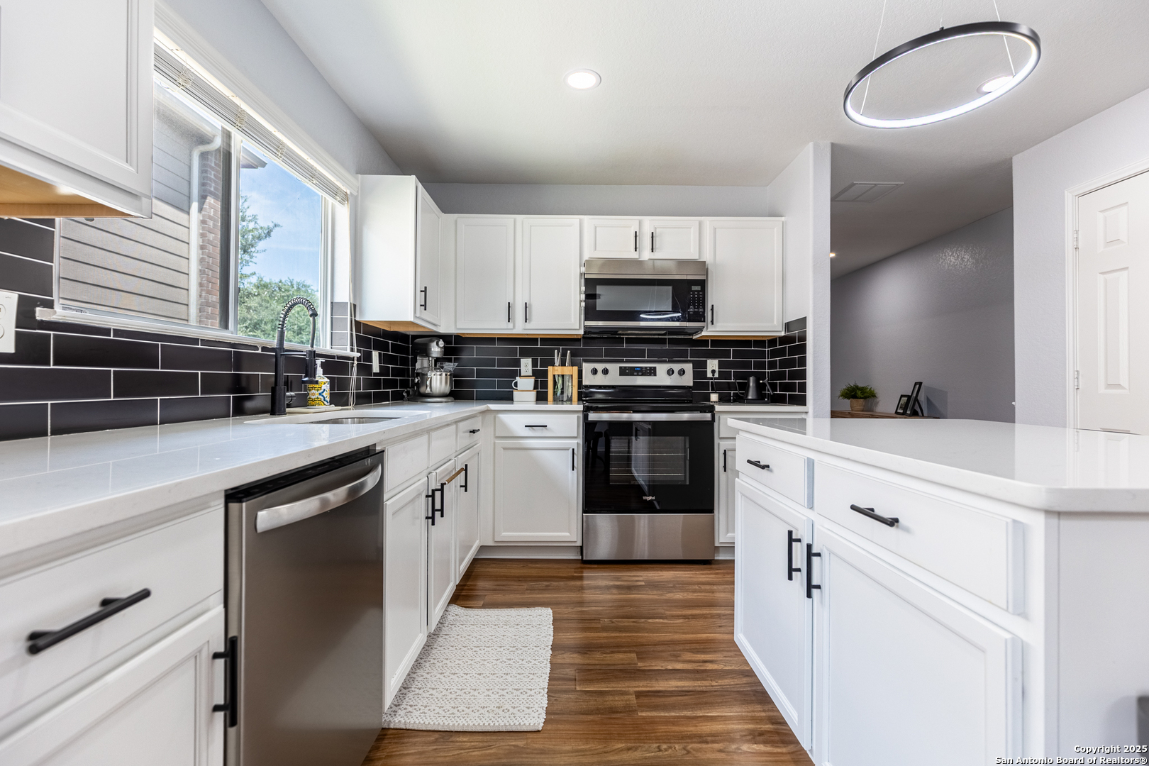9518 Lookover Bay Converse, TX 78109 - Photo 5 of 30 a kitchen with kitchen island granite countertop a sink appliances cabinets and a counter top space