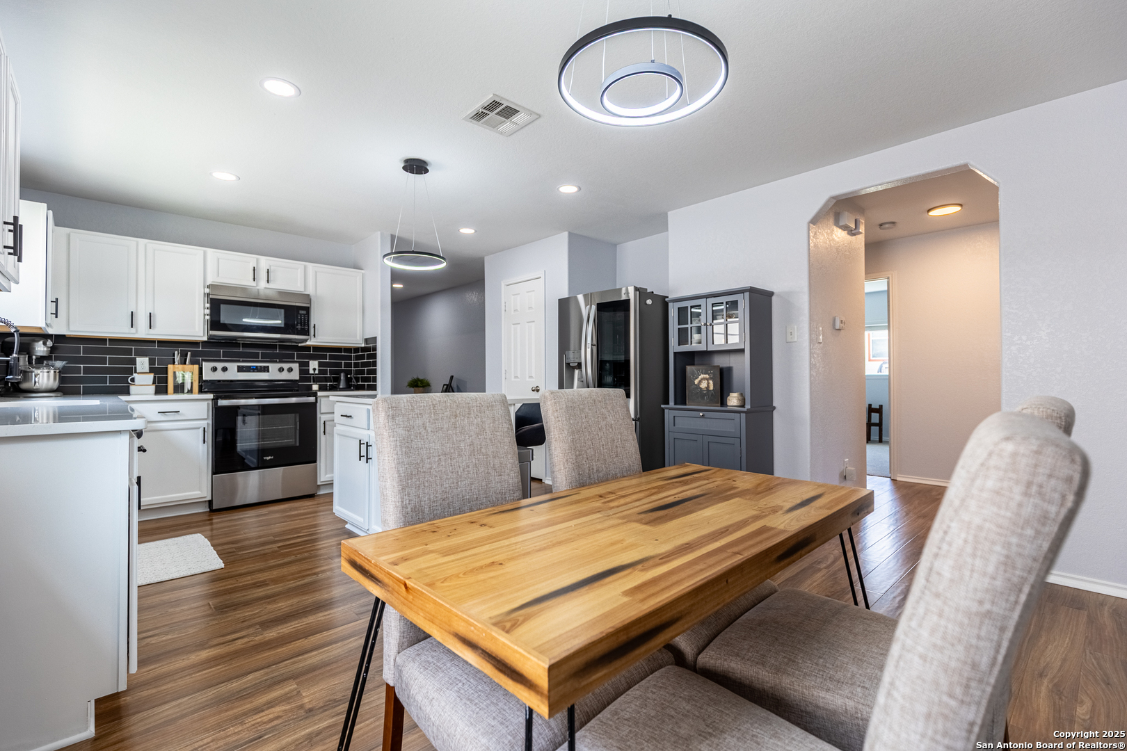 9518 Lookover Bay Converse, TX 78109 - Photo 9 of 30 a kitchen with stainless steel appliances granite countertop a refrigerator a stove top oven a sink dishwasher a dining table and chairs with wooden floor
