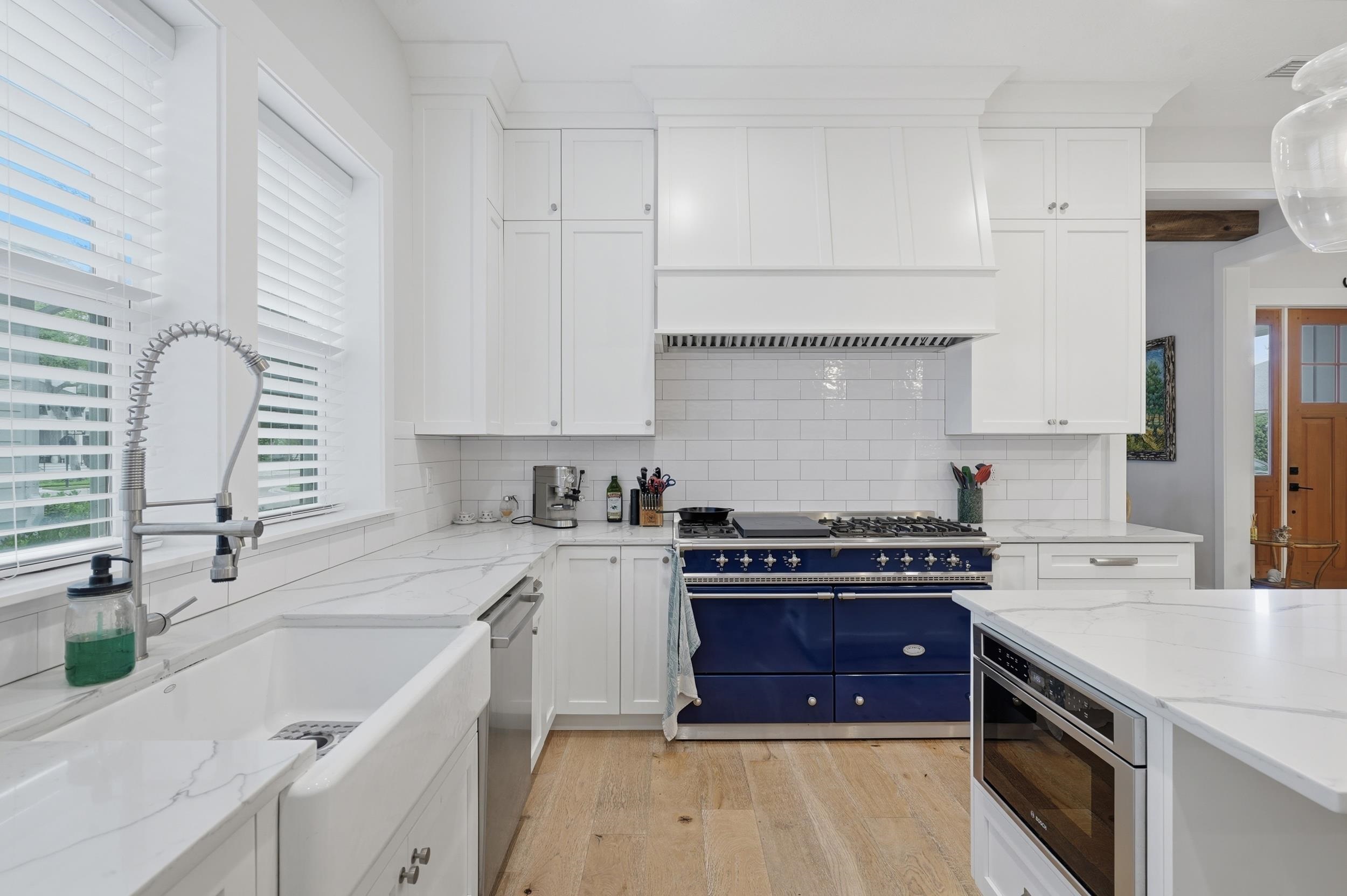 240 Ridgeway Road St. Augustine, FL 32080 - Photo 20 of 38 Dual tone kitchen featuring stainless steel appliances, light wood-type flooring, light stone countertops, dual tone cabinets, and tasteful backsplash