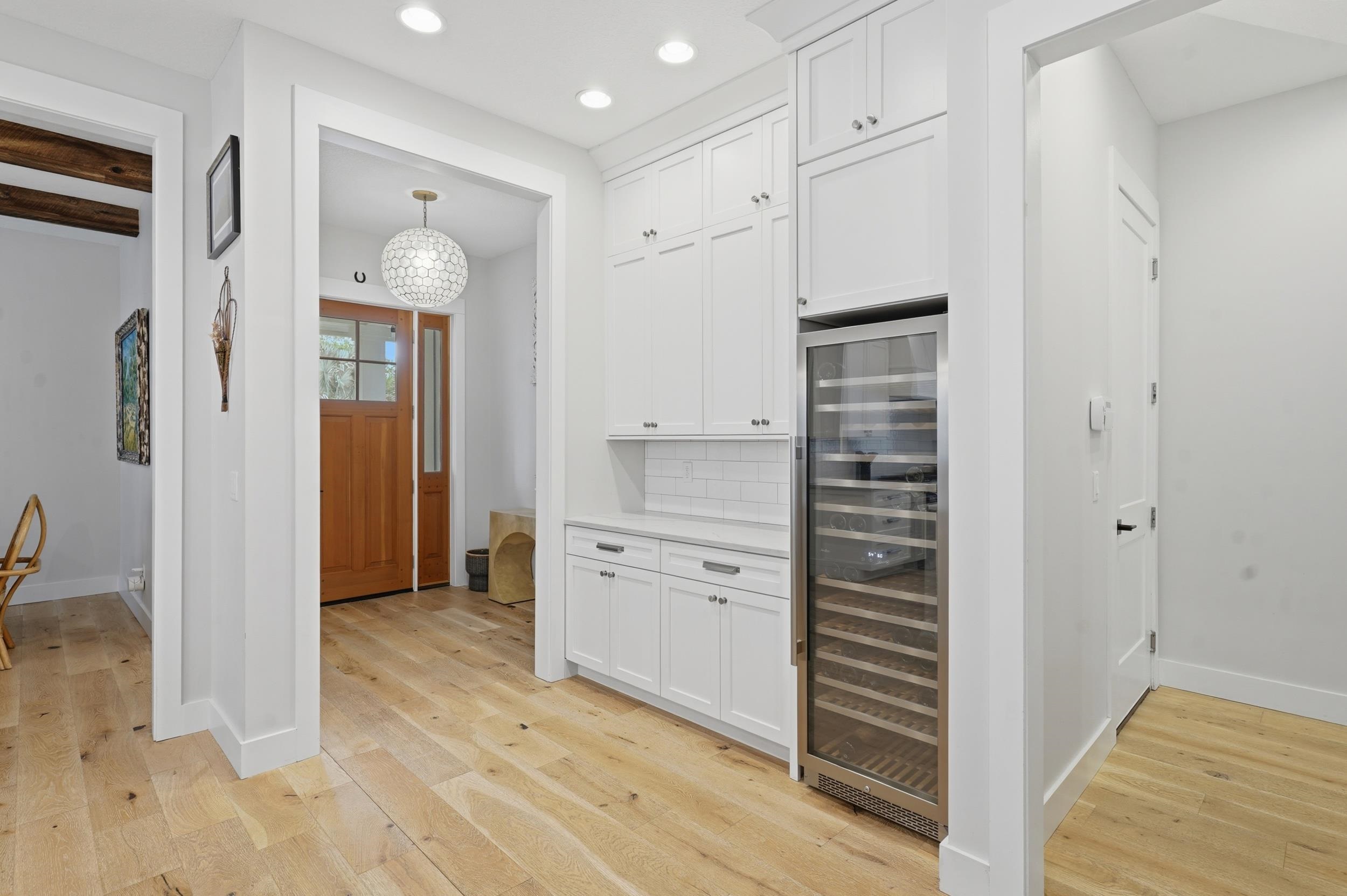 240 Ridgeway Road St. Augustine, FL 32080 - Photo 22 of 38 Kitchen featuring wine cooler, tasteful backsplash, light wood-type flooring, and white cabinetry