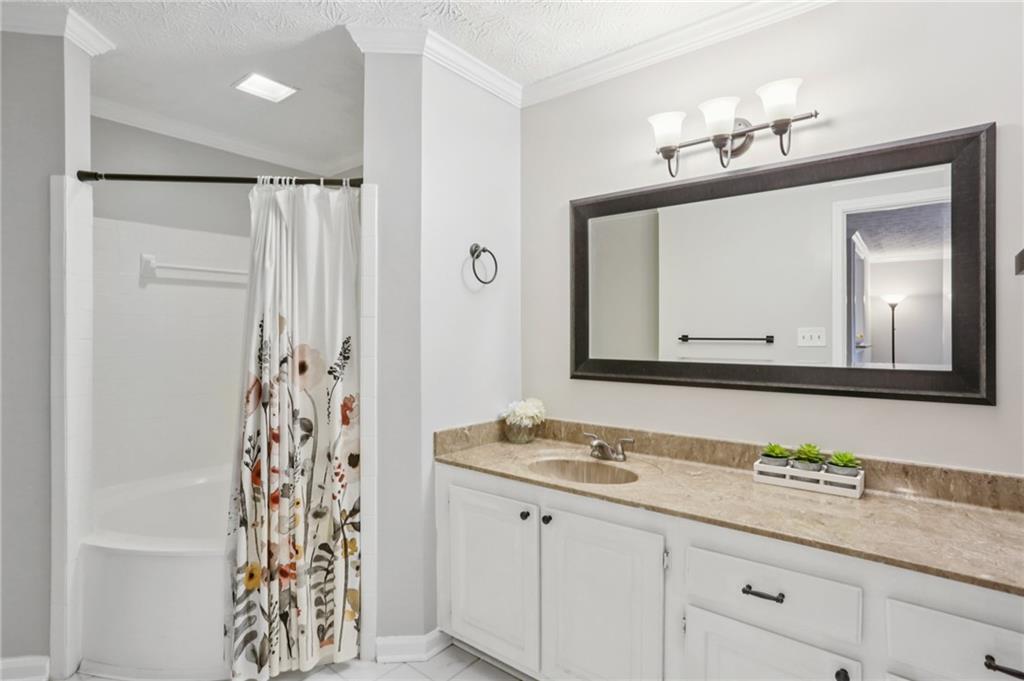 970 Sidney Marcus Boulevard Northeast, Unit 2115 Atlanta, GA 30324 - Photo 12 of 21 a bathroom with a granite countertop sink vanity and mirror