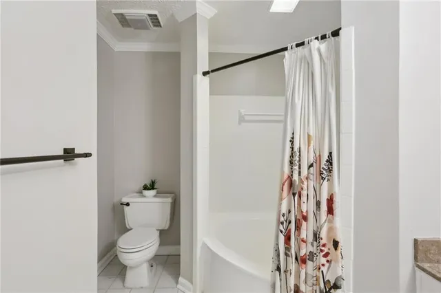 a bathroom with a toilet and a shower curtain