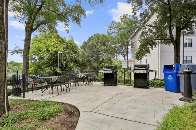 a view of a patio with table and chairs potted plants and a large tree