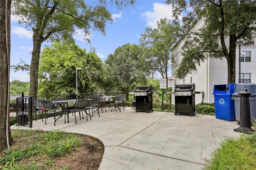 970 Sidney Marcus Boulevard Northeast, Unit 2115 Atlanta, GA 30324 - Photo 19 of 21 a view of a patio with table and chairs potted plants and a large tree