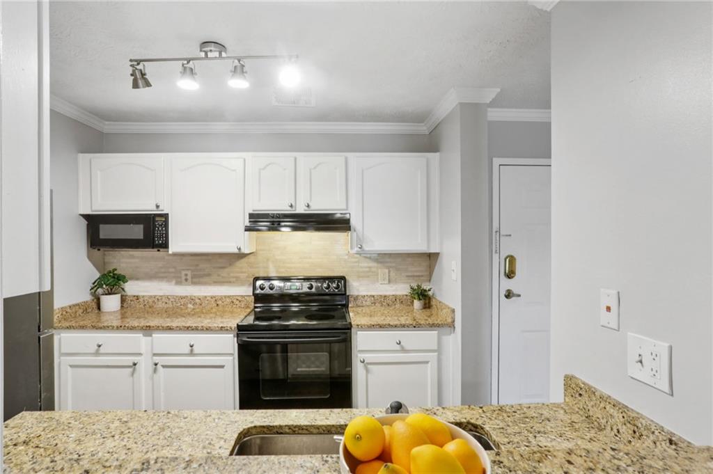 970 Sidney Marcus Boulevard Northeast, Unit 2115 Atlanta, GA 30324 - Photo 7 of 21 a kitchen with stainless steel appliances granite countertop a stove a sink and a refrigerator