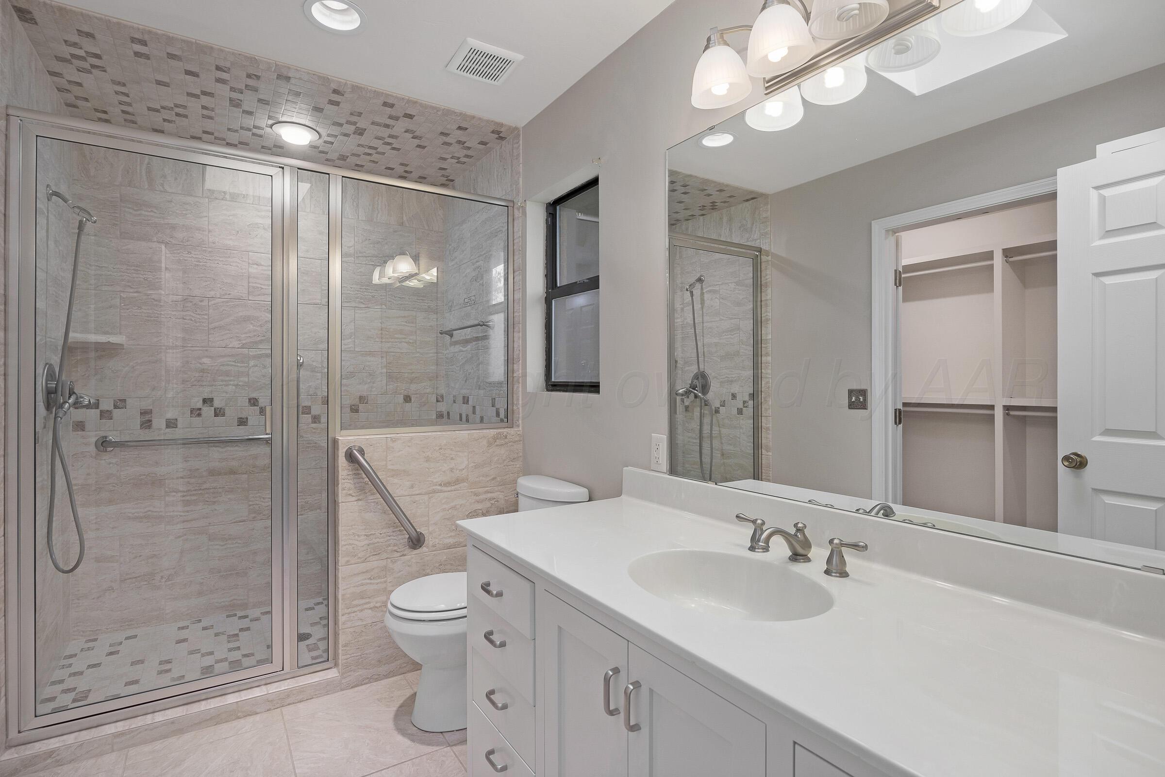 5403 Camp Lane Amarillo, TX 79110 - Photo 11 of 25 a bathroom with a granite countertop sink a toilet and shower