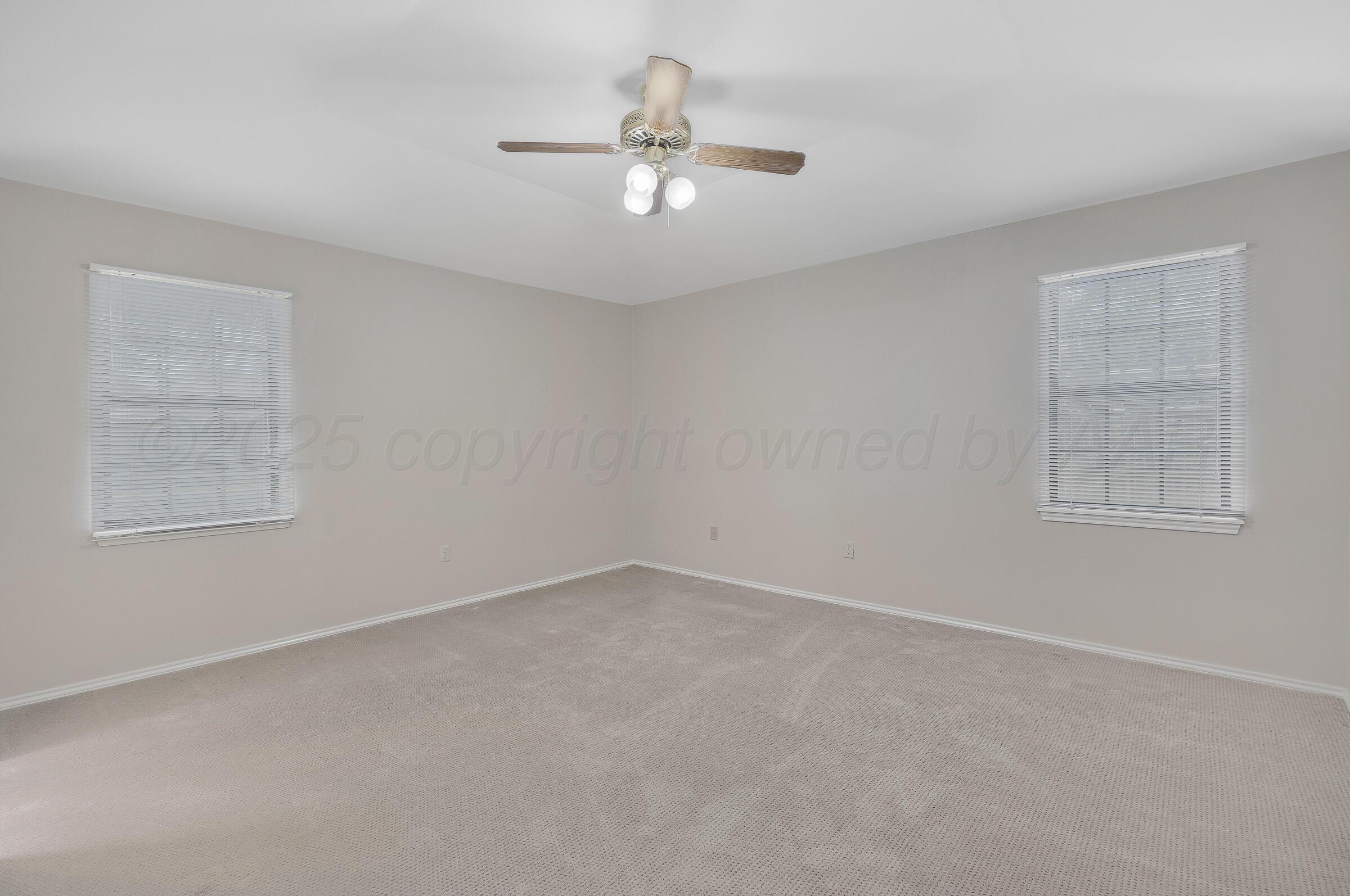 5403 Camp Lane Amarillo, TX 79110 - Photo 12 of 25 an empty room with a chandelier fan and windows