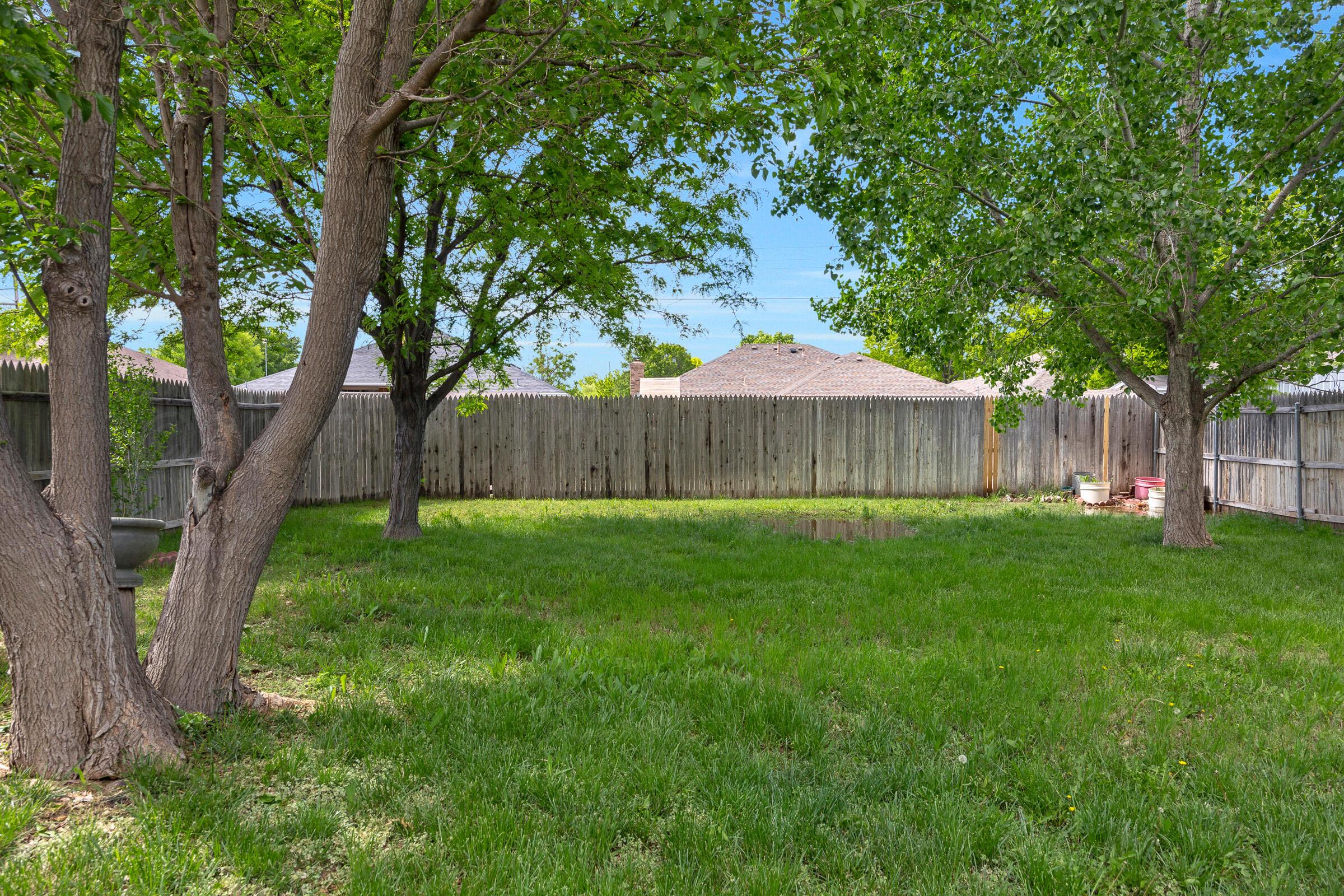 5403 Camp Lane Amarillo, TX 79110 - Photo 20 of 25 a view of a backyard with large trees and wooden fence