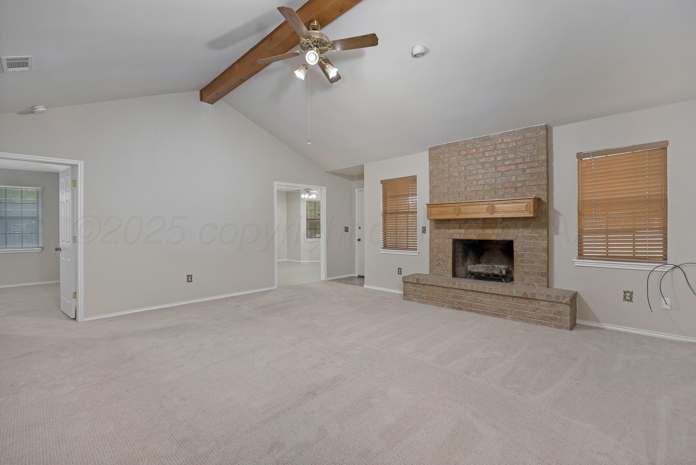 5403 Camp Lane Amarillo, TX 79110 - Photo 3 of 25 an empty room with windows fireplace and fan