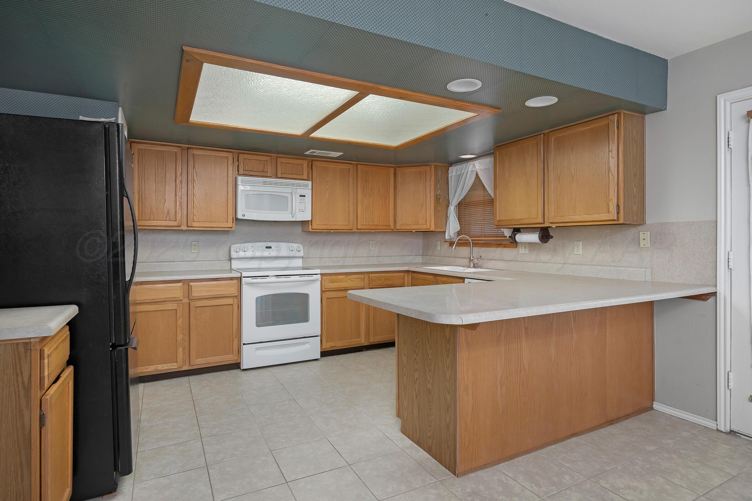 5403 Camp Lane Amarillo, TX 79110 - Photo 6 of 25 a kitchen with a stove a sink and a refrigerator