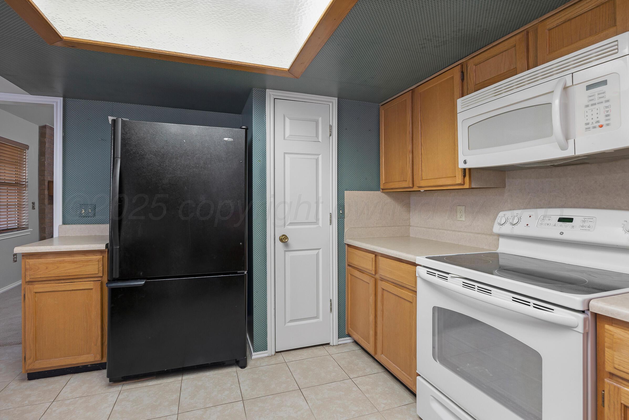5403 Camp Lane Amarillo, TX 79110 - Photo 8 of 25 a kitchen with a refrigerator stove and cabinets