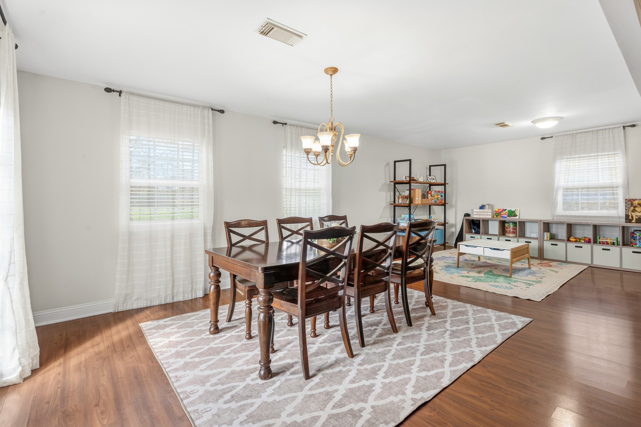 2104 Rose Road Pearland, TX 77581 - Photo 15 of 43 a dining room with wooden floor a chandelier a wooden table and chairs
