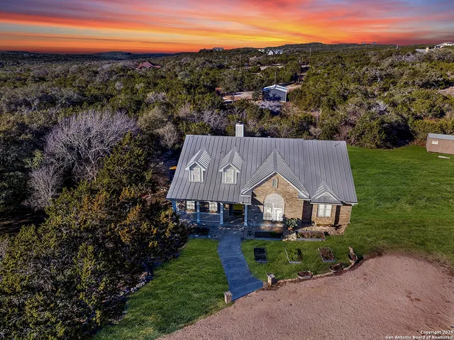 a aerial view of a house with a yard and lake view