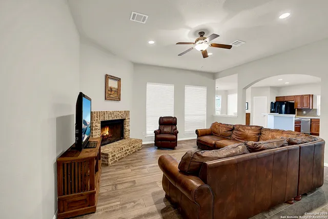 a living room with furniture a fireplace and a flat screen tv