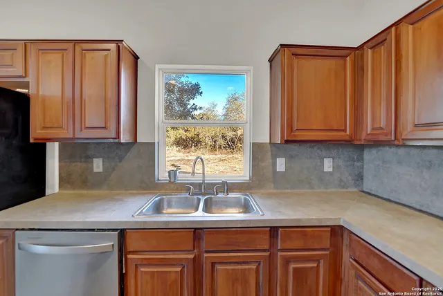 a kitchen with a sink a refrigerator and window