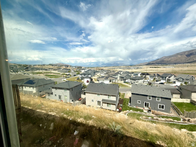 1823 South Longview Road Santaquin, UT 84655 - Photo 69 of 69 Neighborhood setting featuring a mix of residential properties, paved streets, and mountainous terrain in the distance under a partly cloudy sky