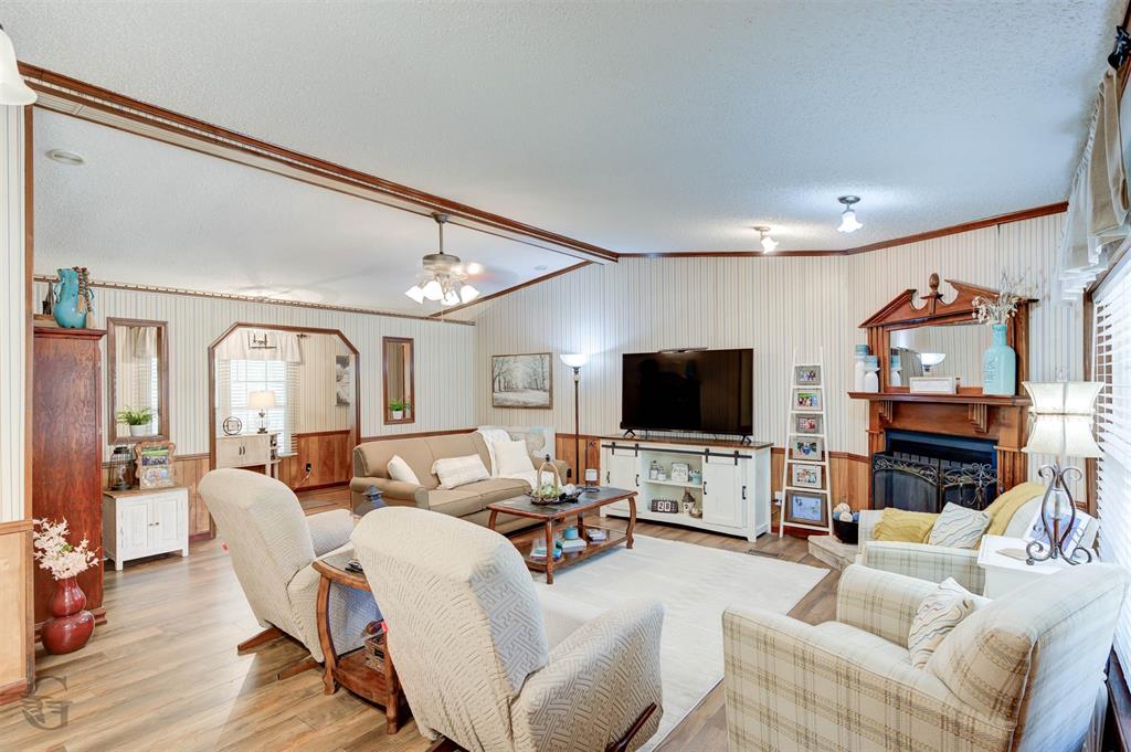 8839 Sebastian Road Keithville, LA 71047 - Photo 10 of 40 Spacious living area featuring wood-finish flooring, a decorative fireplace with a mantel, and built-in shelving